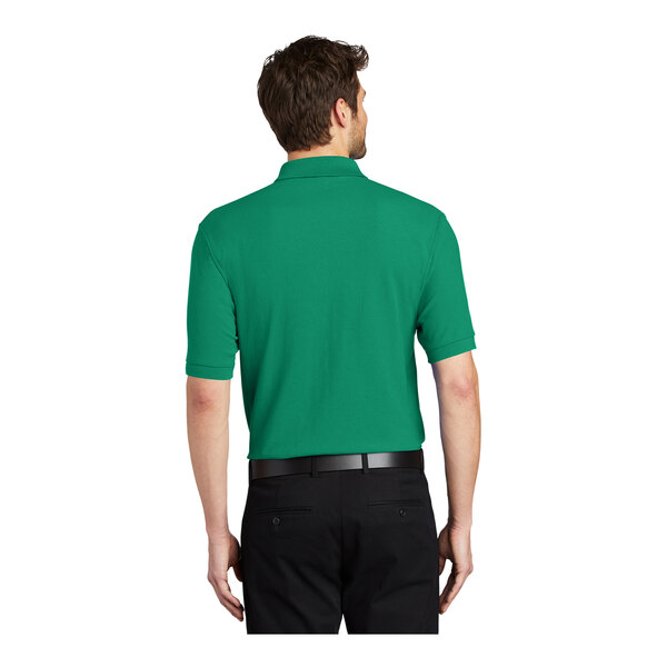 A man wearing a Kelly green Port Authority polo shirt.