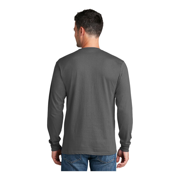 A man wearing a charcoal Port & Company long sleeve t-shirt.