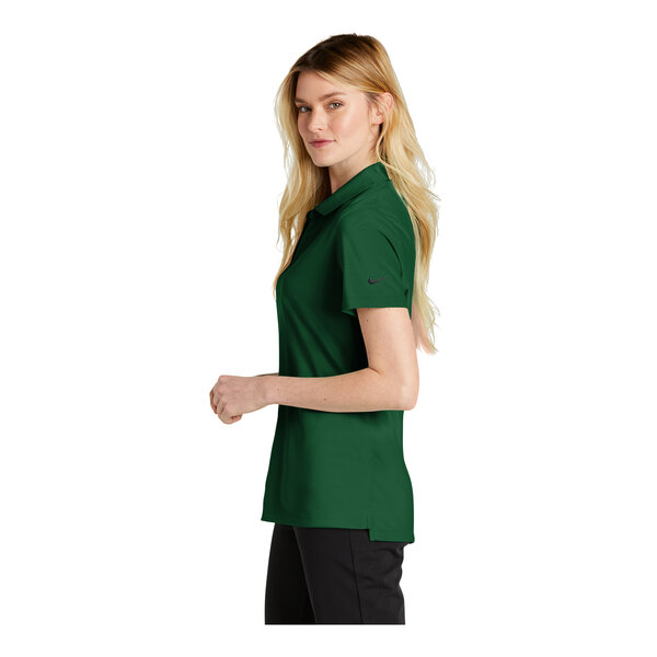A woman wearing a green Nike polo shirt.
