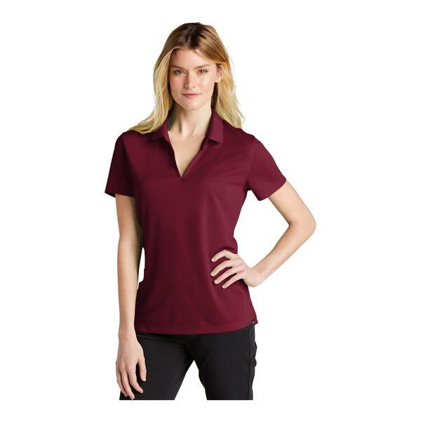A woman wearing a maroon Nike polo shirt.