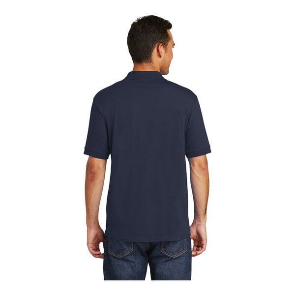 A man wearing a deep navy Port & Company short sleeve polo shirt.