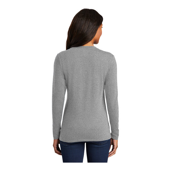 A woman wearing a Port & Company athletic heather long sleeve shirt.