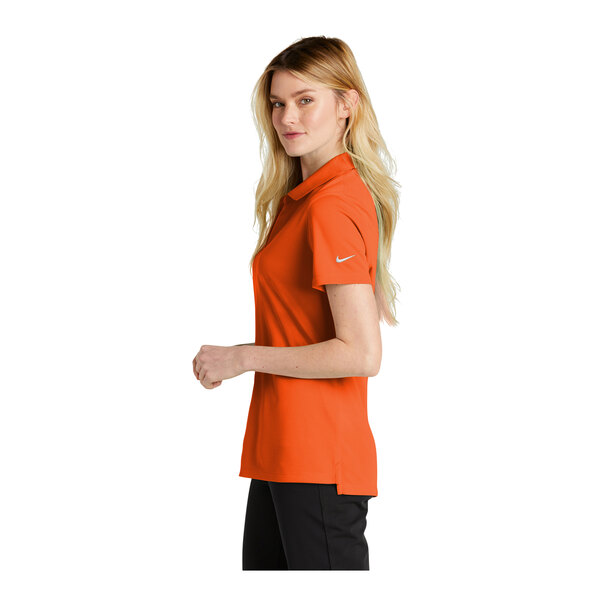 A woman wearing a Nike Brilliant Orange polo shirt.