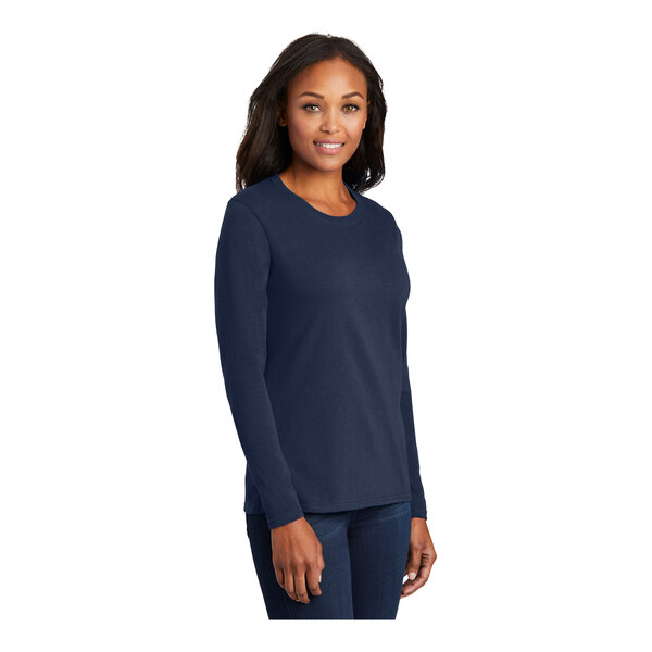 A woman wearing a Port & Company navy long sleeve t-shirt.
