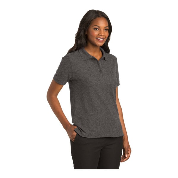 A woman wearing a Port Authority charcoal heather gray polo shirt.