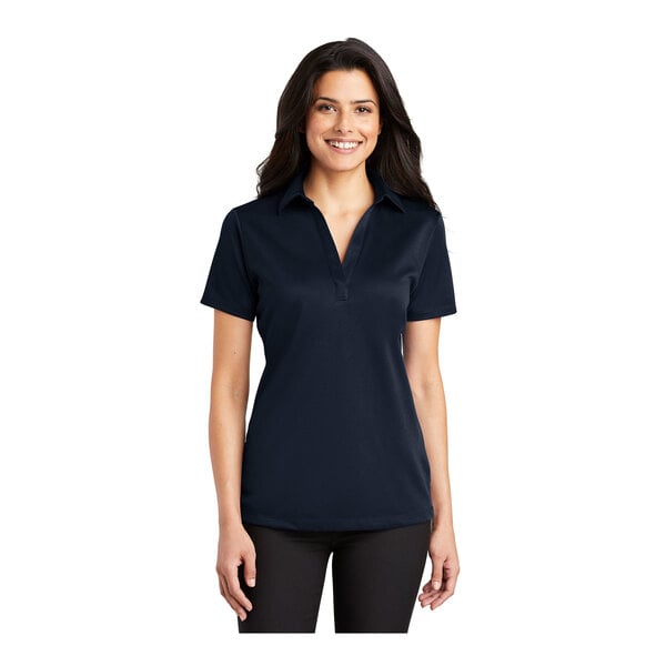 A woman wearing a navy Port Authority short sleeve polo shirt.