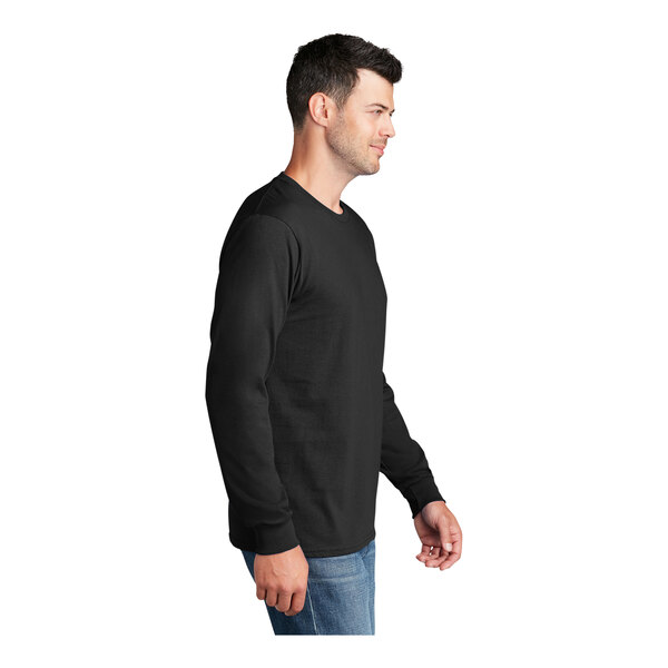A man wearing a jet black Port & Company long sleeve t-shirt.