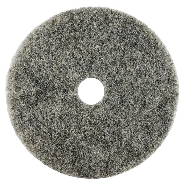 A grey circular Scrubble light burnishing floor pad with a hole in the middle.