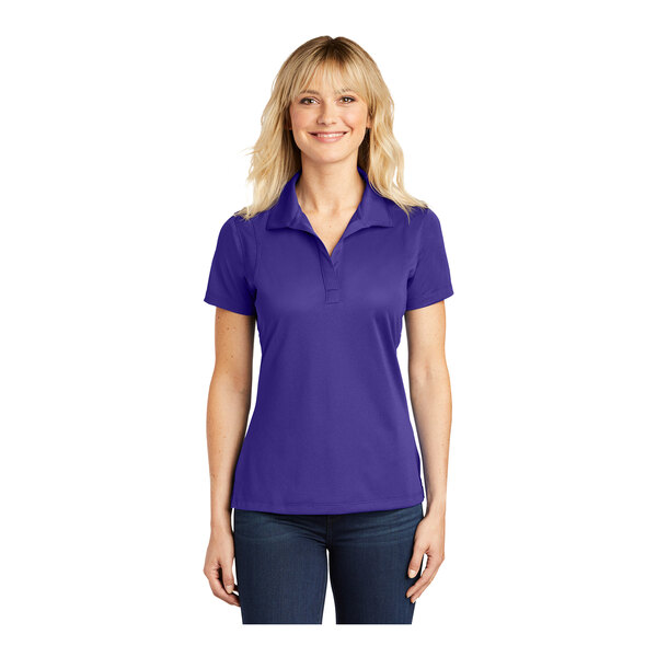 A woman wearing a purple Sport-Tek polo shirt.