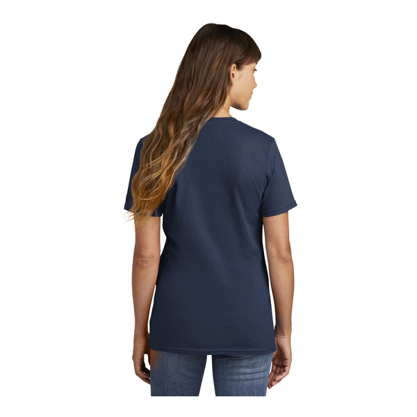 A woman wearing a navy blue Port & Company short sleeve t-shirt.