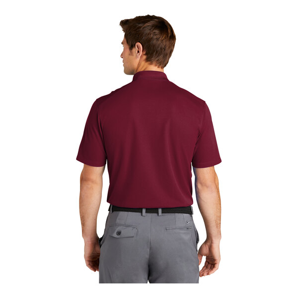 A man wearing a red Nike polo shirt with a pocket on the back.