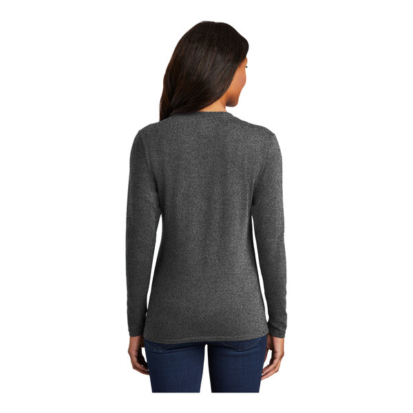 A woman wearing a dark heather grey Port & Company long sleeve T-shirt.