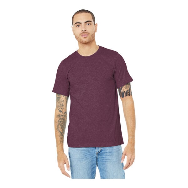 A man wearing a maroon Bella + Canvas t-shirt and jeans.