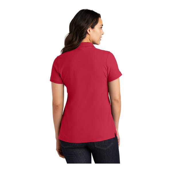 A woman wearing a rich red Port Authority polo shirt.