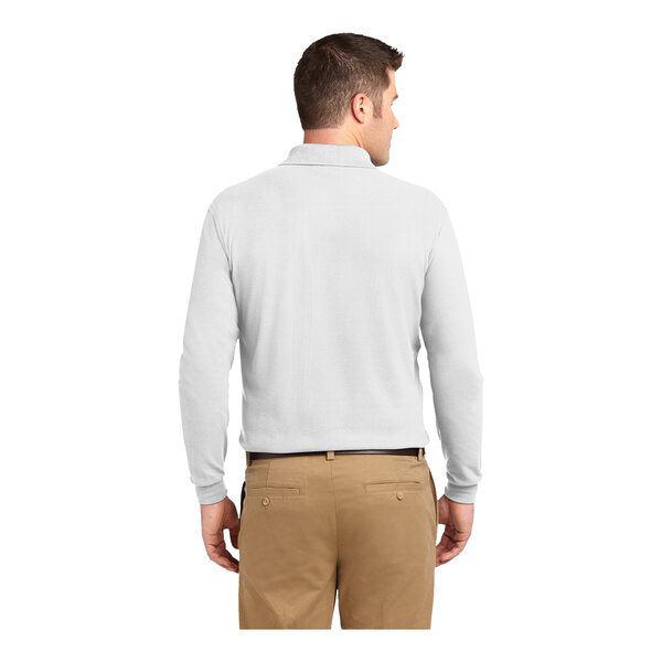 A man wearing a white Port Authority® long sleeve polo shirt.