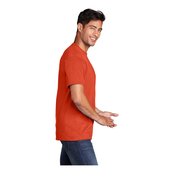 A man holding an extra large orange Port & Company T-shirt.