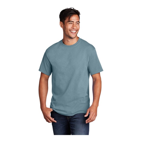 A man smiling and wearing a stonewashed blue Port & Company T-shirt.