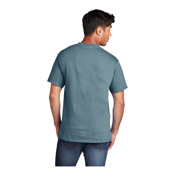 A man wearing a stonewashed blue Port & Company T-shirt.