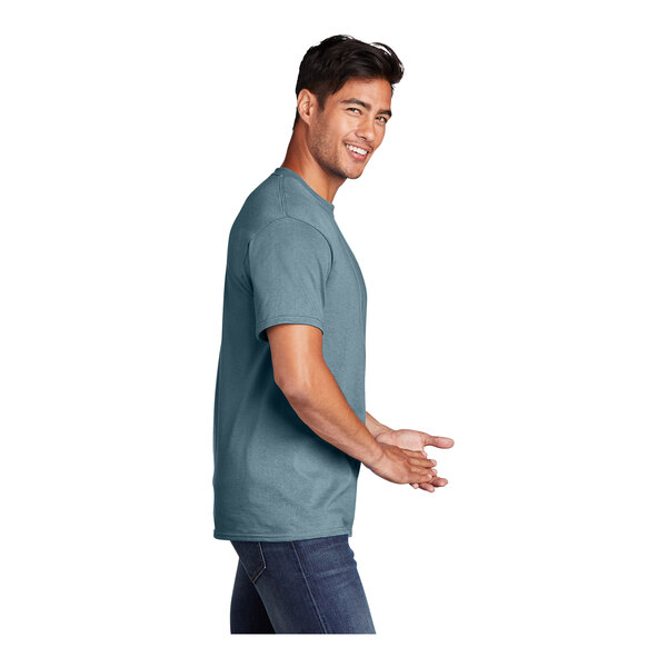 A man wearing a stonewashed blue Port & Company T-shirt.