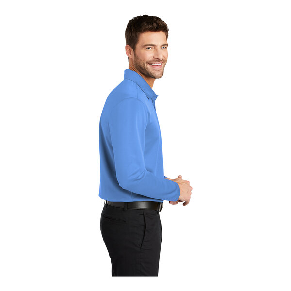A man wearing a Carolina blue Port Authority long sleeve polo shirt.