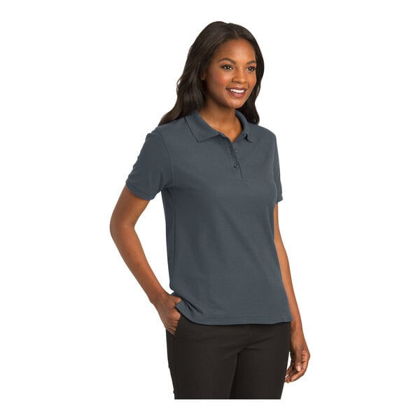 A woman wearing a Port Authority steel gray short sleeve polo shirt.