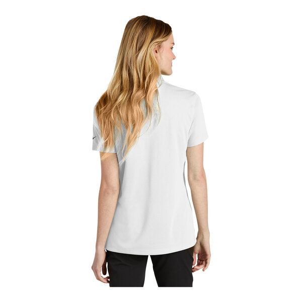 A woman wearing a white Nike polo shirt.