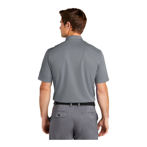 A man wearing a cool grey Nike Dri-Fit polo shirt.