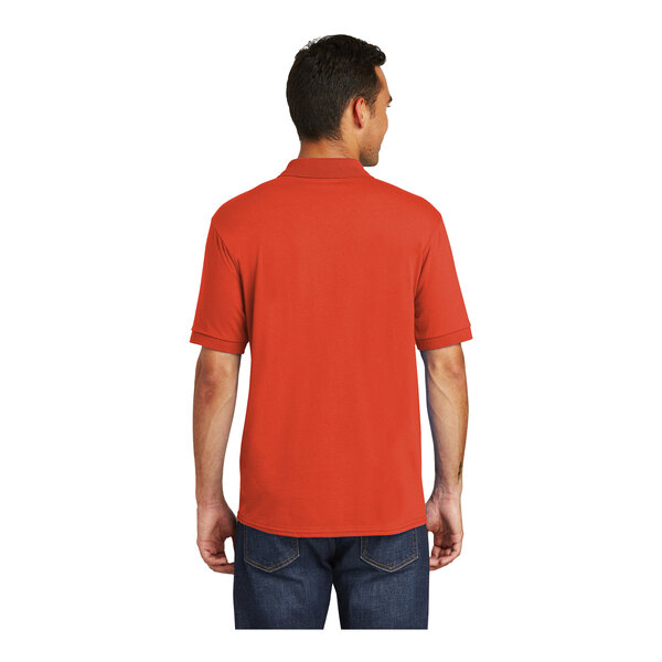 A man wearing an orange Port & Company jersey knit polo shirt.