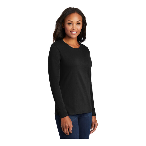 A woman wearing a Port & Company jet black long sleeve t-shirt.