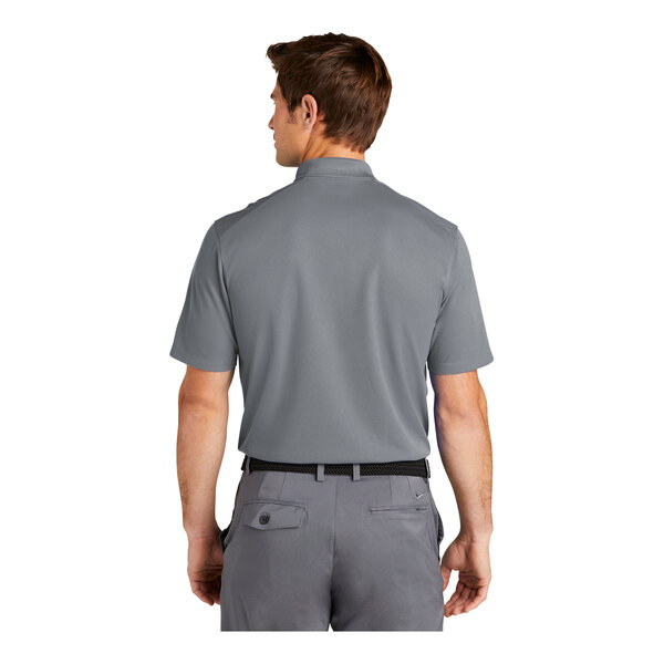 A man wearing a Nike grey polo with black and white details.