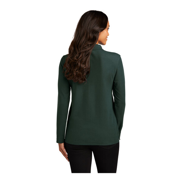 A woman with long brown hair wearing a dark green long sleeve Port Authority polo shirt.