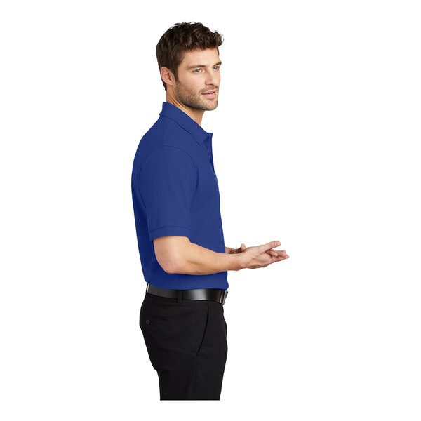 A man wearing a Port Authority royal blue Silk Touch Pique Polo.