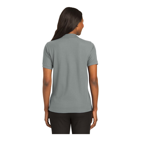 A woman wearing a Port Authority cool gray short sleeve silk touch polo shirt.