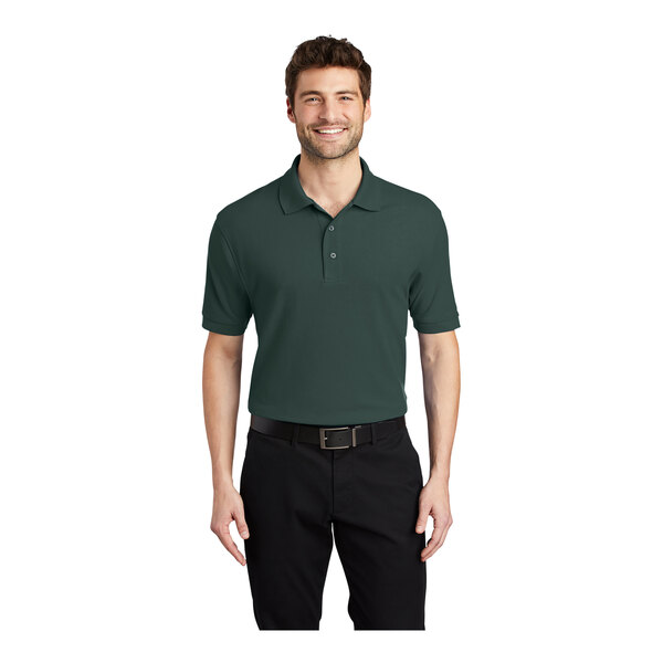 A man wearing a dark green Port Authority® silk touch pique polo shirt.