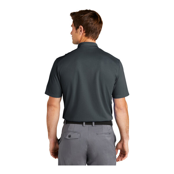 A man wearing a charcoal Nike Dri-Fit polo.