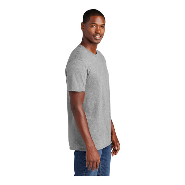 A man wearing a light heather grey District T-shirt.