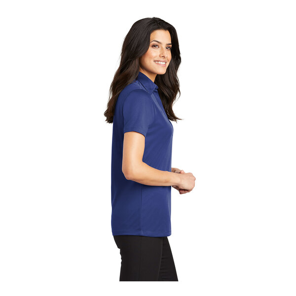 A woman wearing a royal blue Port Authority silk touch polo shirt.