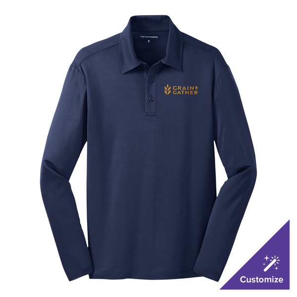 A navy Port Authority long sleeve polo shirt on a counter with the school's logo.