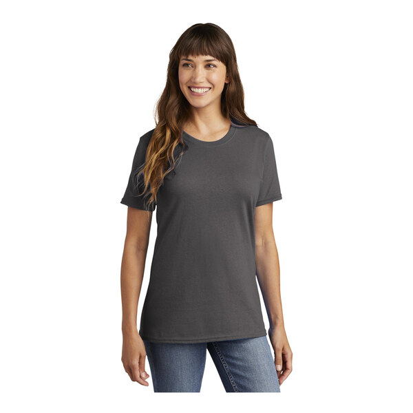 A woman wearing a charcoal Port & Company short sleeve T-shirt.