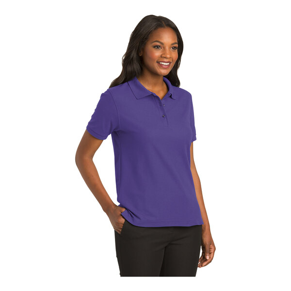 A woman wearing a purple Port Authority silk touch polo shirt.