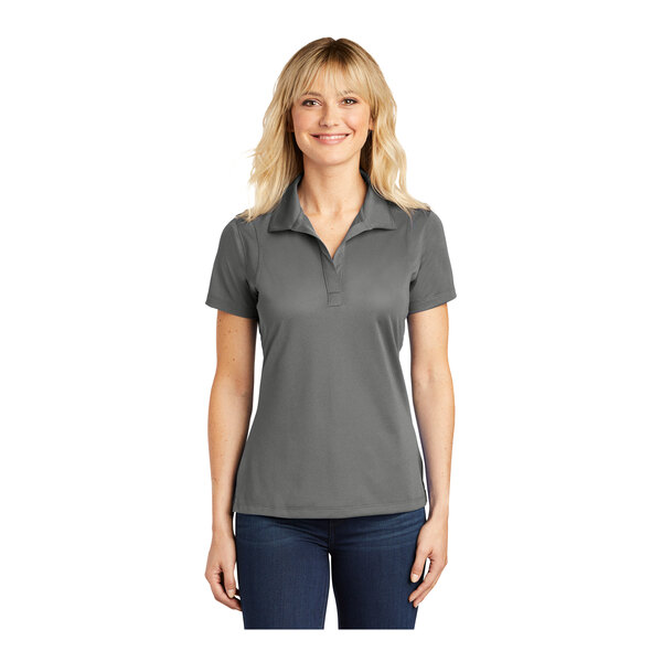 A woman wearing a grey Sport-Tek performance polo shirt.