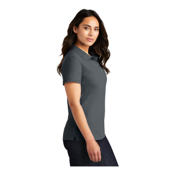 A woman wearing a graphite Port Authority short sleeve polo shirt.