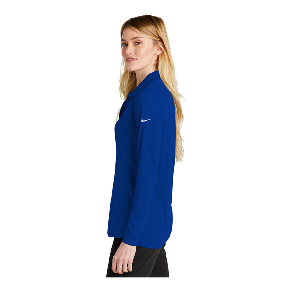 A woman wearing a Nike royal blue long sleeve polo shirt.