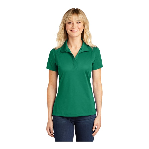 A woman wearing a Kelly green Sport-Tek short sleeve polo.