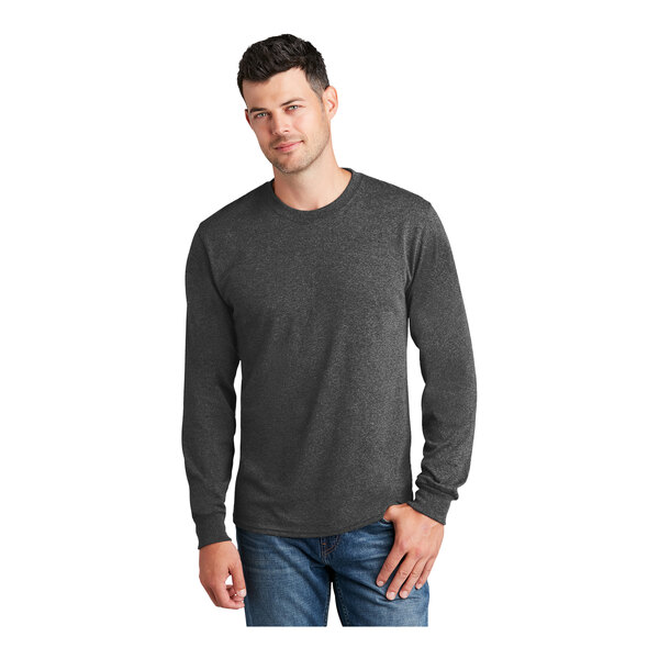 A man wearing a Port & Company long sleeve t-shirt in dark heather gray.