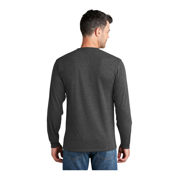 A man wearing a dark heather grey Port & Company long sleeve t-shirt.