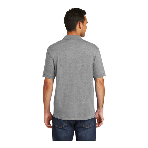A man wearing a Port & Company athletic heather grey polo shirt.