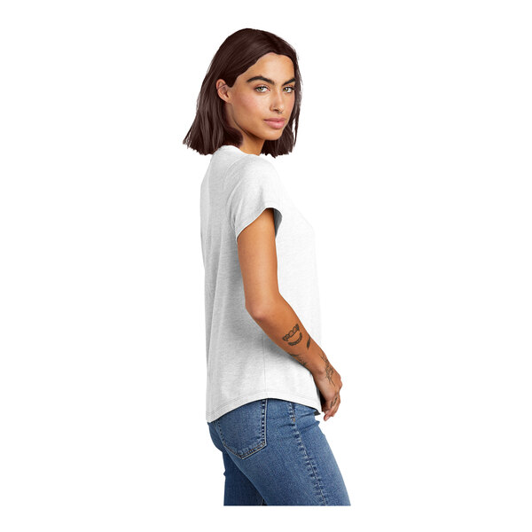 A woman's arm with a tattoo wearing a white AllMade short sleeve T-shirt.