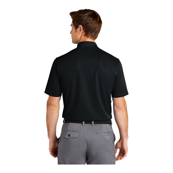 A man wearing a black Nike polo shirt with a white Nike logo on the back.