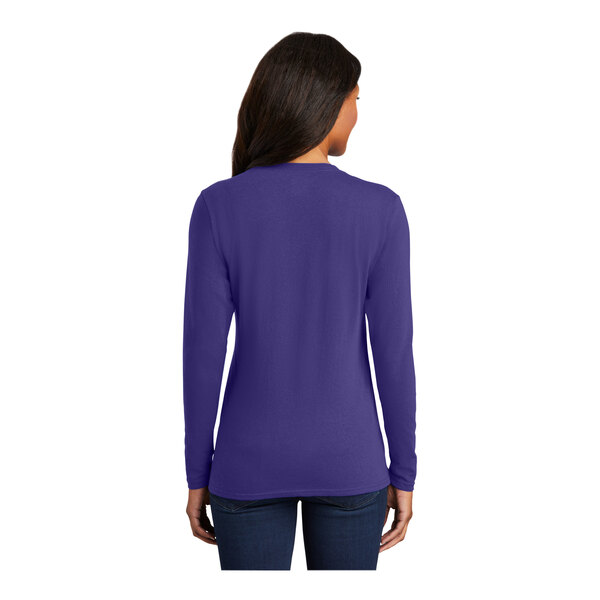 A woman wearing a purple Port & Company long sleeve t-shirt.